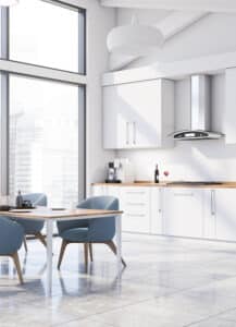 Cuisine moderne blanche lumineuse avec une grande baie vitrée donnant sur des gratte-ciels, une table à manger et des chaises bleues.