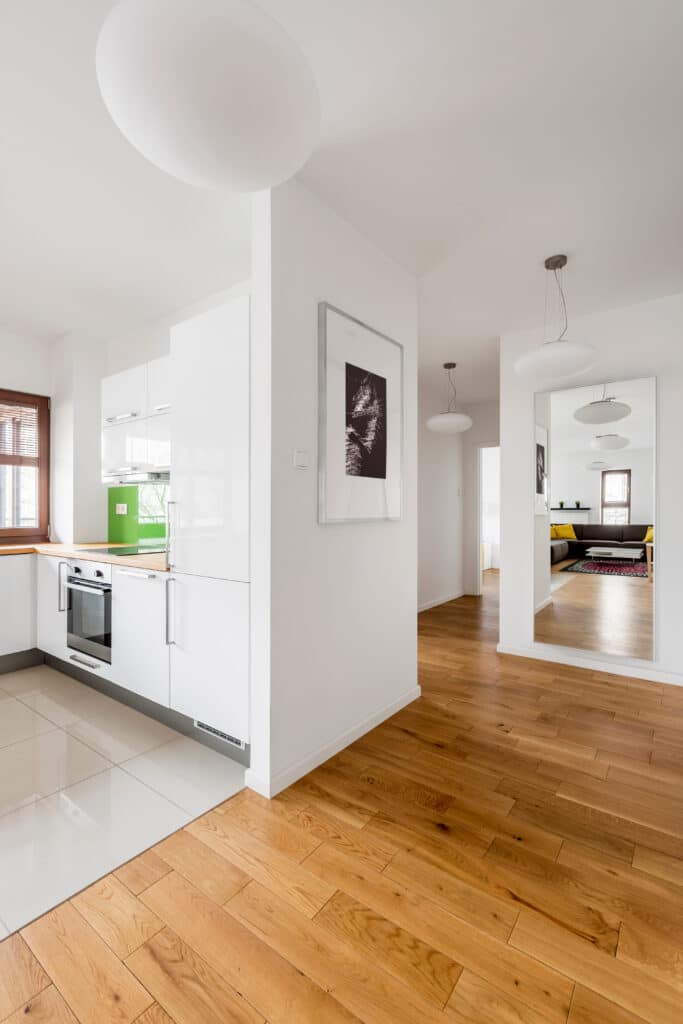 Cuisine Moderne Blanche et Parquet Chêne Chaleureux Intérieur moderne avec cuisine blanche et parquet en bois clair contrastant avec des carreaux brillants de la cuisine.