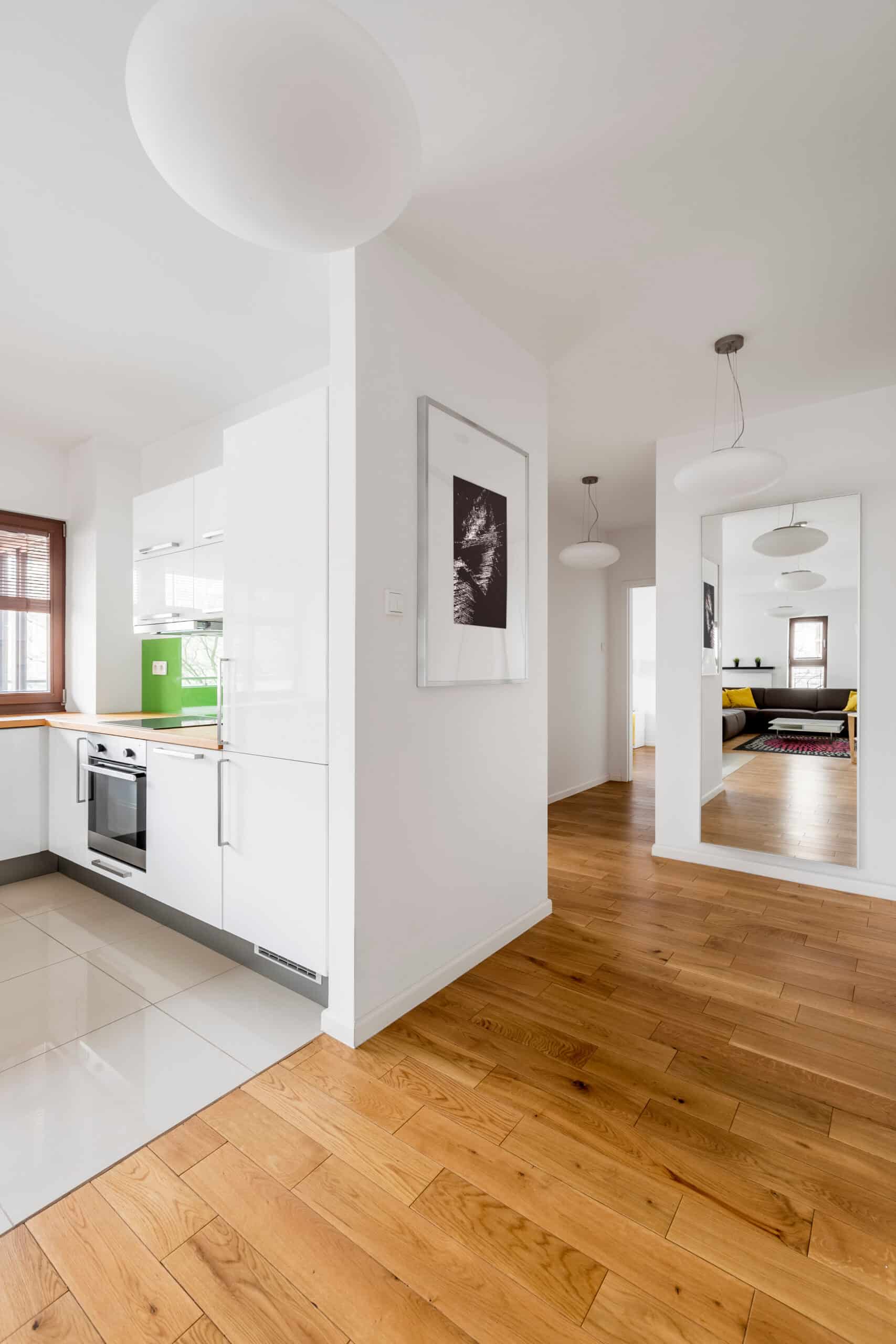 Cuisine moderne blanche lumineuse avec vue sur ville Cuisine moderne blanche lumineuse avec une grande baie vitrée donnant sur des gratte-ciels, une table à manger et des chaises bleues.