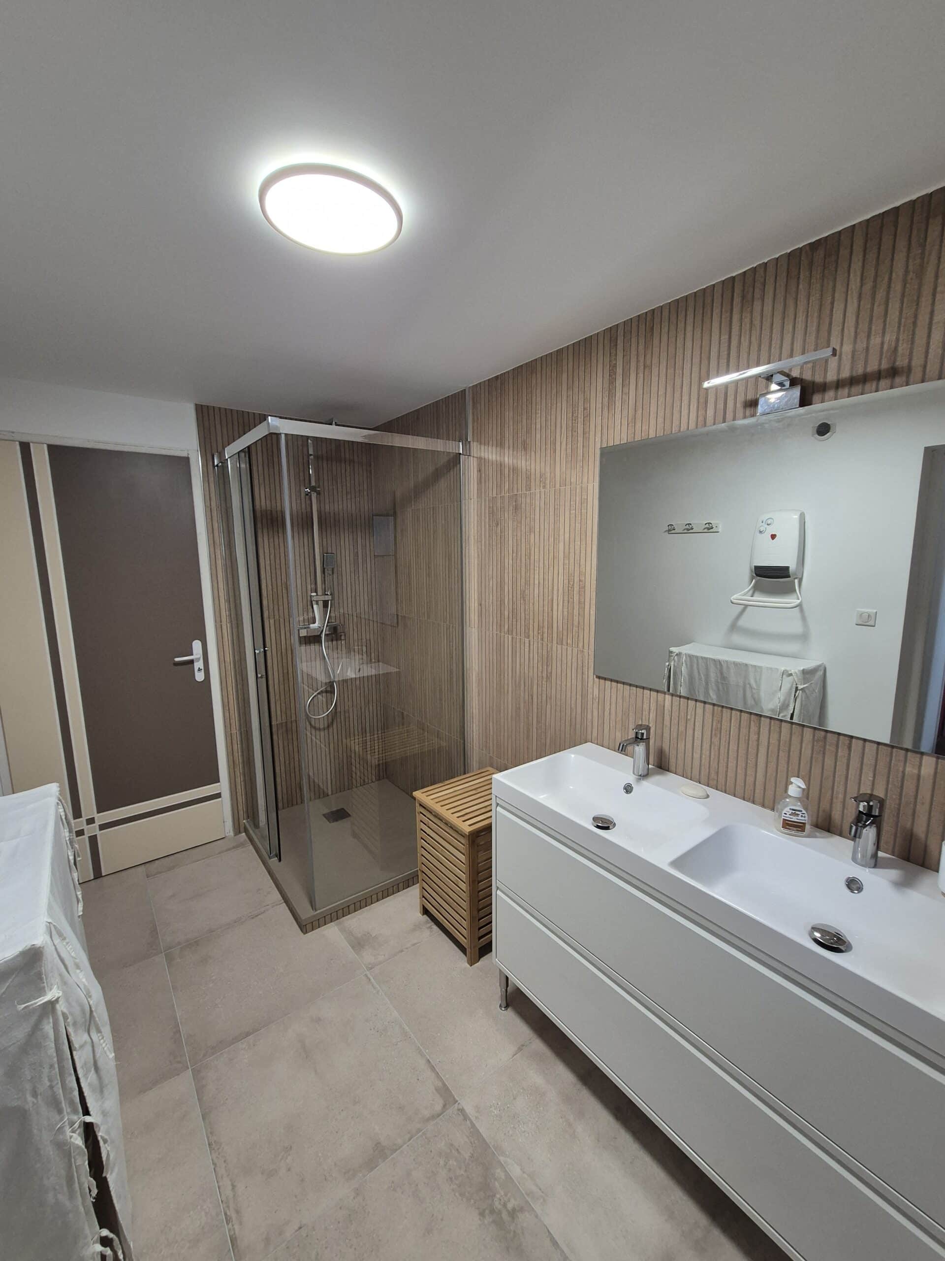 Cuisine moderne blanche lumineuse avec vue sur ville Cuisine moderne blanche lumineuse avec une grande baie vitrée donnant sur des gratte-ciels, une table à manger et des chaises bleues.